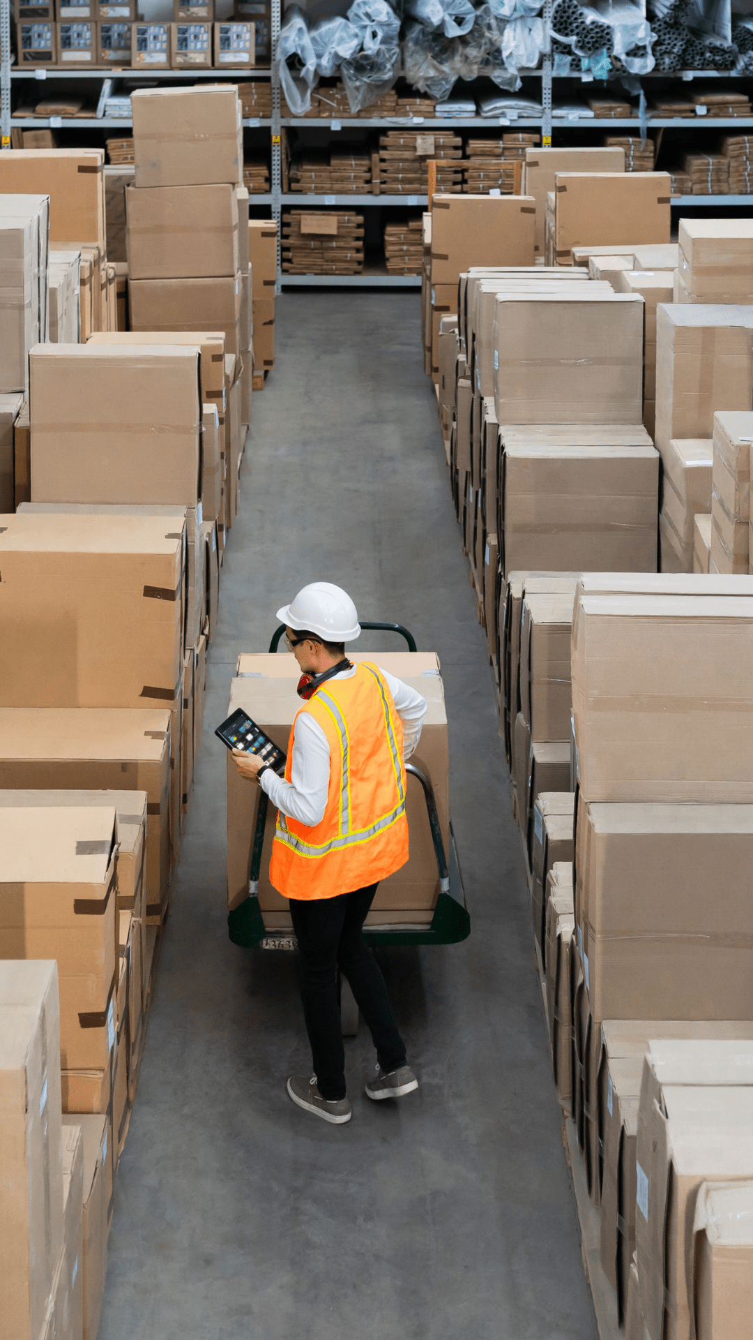 Logistiker von H & H Logistics prüft mit Tablet Stückgut im Lager für europaweite Transporte.